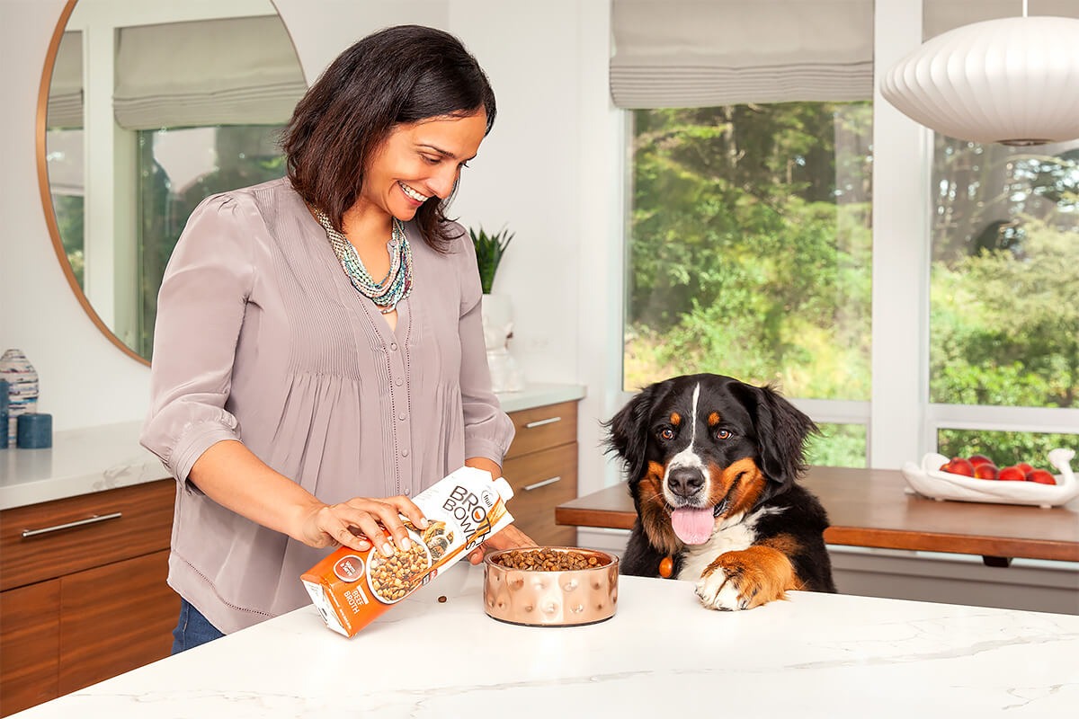 women-pouring-food-topper-on-dog-food-excited-dog.2